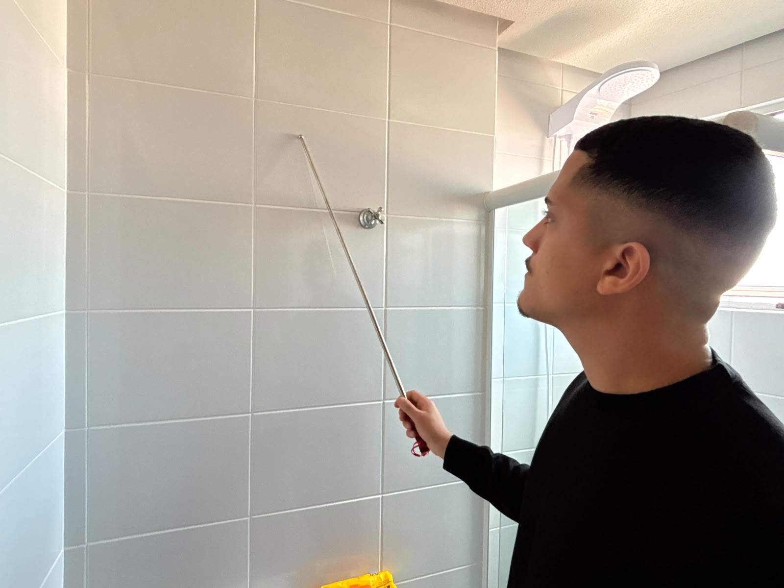 Alex conferindo o revestimento cerâmico durante uma vistoria