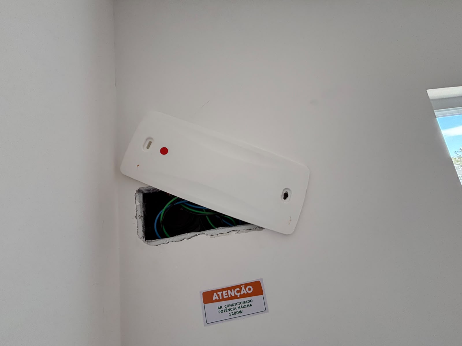 Caixa elétrica com tampa deslocada e fiação aparente durante a inspeção